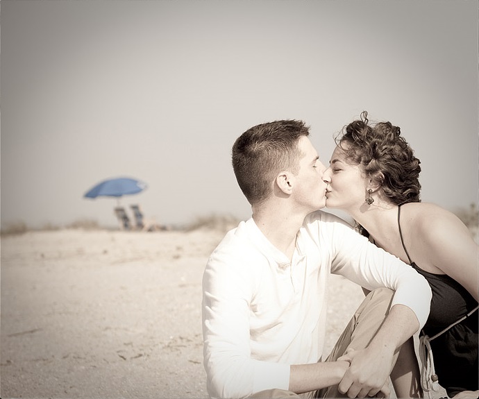 The couple is kissing on the beach