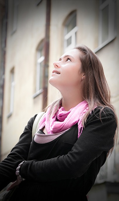 The young lady is looking at the sky