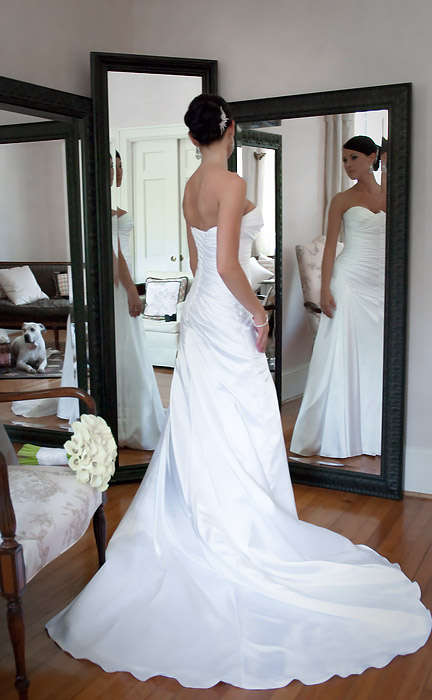 The bride is posing in front of the mirror